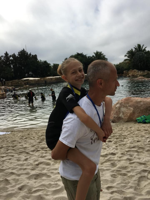 Shae and dad piggyback at Discovery Cove